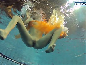 Yellow and red dressed nubile underwater